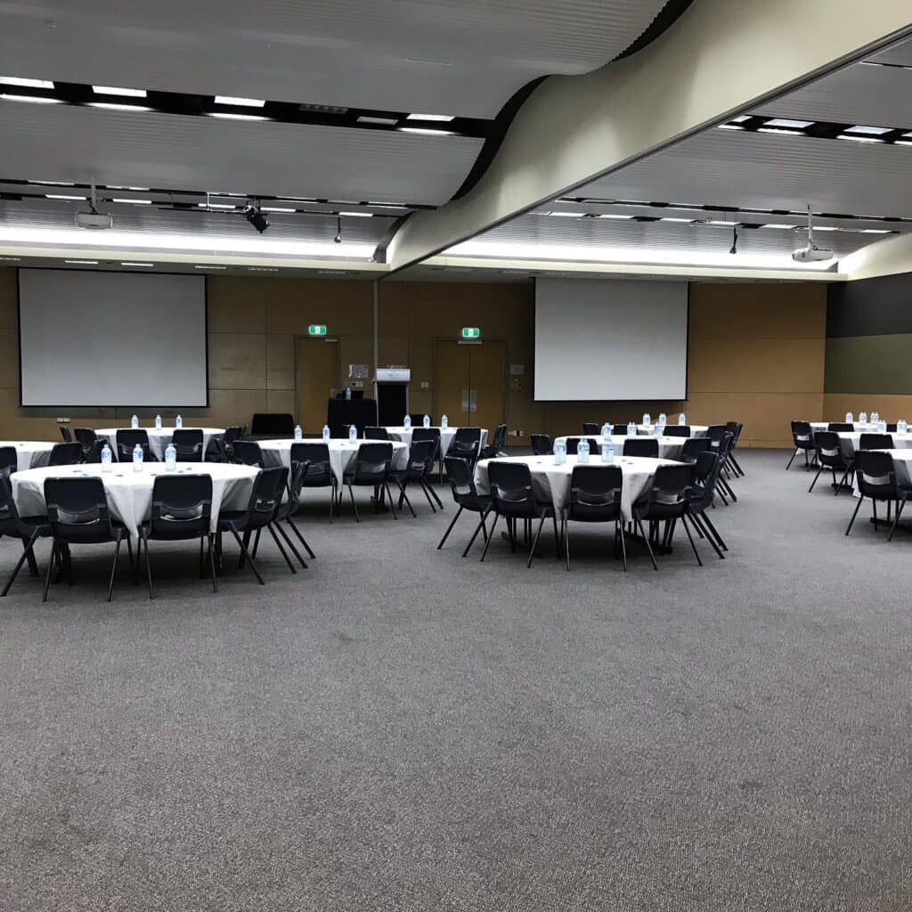 A large room in the conference centre is set up with tables and chairs ready for an event.