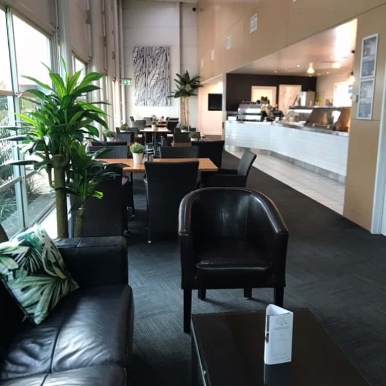 A dining area with tables and comfy seating in the conference centre.