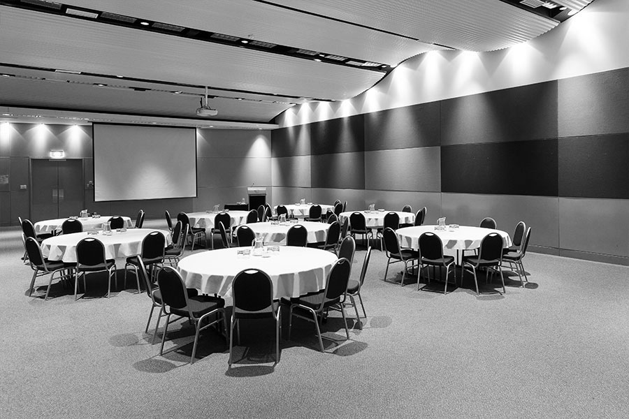 The East Auditorium in the conference centre is set up for an event with circular tables surrounded by chairs.