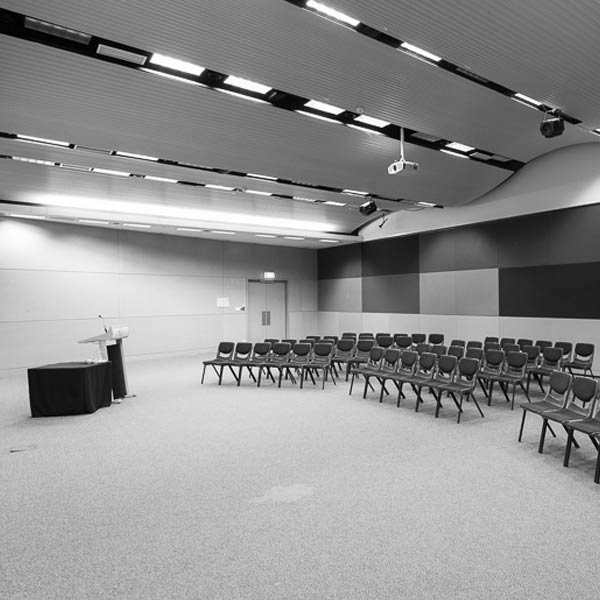 The West Auditorium in the conference centre is set up for an event with a speaker stand and rows of chairs.